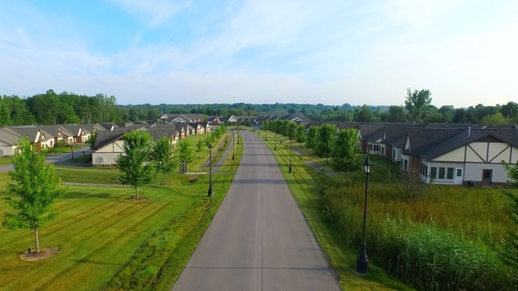 The inviting entrance to Preswick Glen shows the main road and walking path roll past beautiful living units